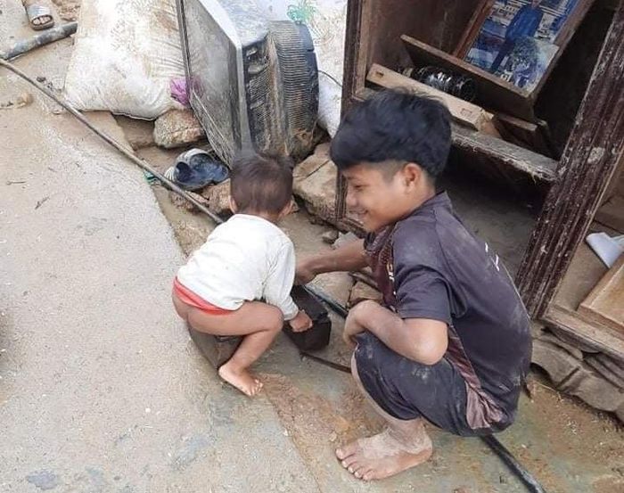 Hai em nhỏ ở xã Phước Thành bên những gì còn sót lại sau trận lũ quét. 