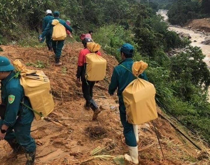 Lực lượng dân quân địa phương gùi lương thực, thực phẩm tiếp tế về cho bà con. 