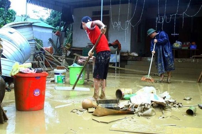 Người dân xã Thanh Đức, huyện Thanh Chương dọn vệ sinh nhà cửa sau lũ. (Ảnh: Tá Chuyên/TTXVN)