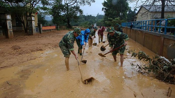 Bộ đội giúp địa phương thu dọn đường giao thông sau lũ ở Quảng Trị. Ảnh: TTXVN