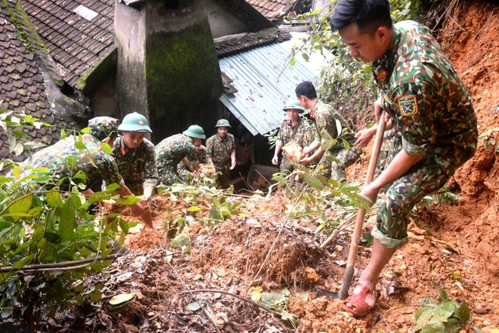 Cán bộ, chiến sĩ Sư đoàn 324 (Quân khu 4) giúp gia đình ông Nguyễn Thanh Hải (75 tuổi) ở thôn 1, xã Thanh Hà khắc phục sạt lở đất do mưa lũ.