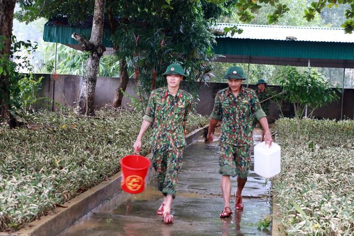 Lũ đi qua để lại một lượng bùn lớn. Vì thế, các chiến sỹ của Sư đoàn 324 phải huy động rất nhiều vật dụng để lấy nước dội rửa lại toàn bộ khuôn viên nhà trường. Ảnh: M.H