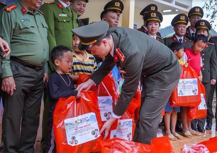 Đoàn viên Đoàn Thanh viên và Hội viên chi hội phụ nữ phòng Tham mưu Công an thành phố Hà Nội trao những món quà nhỏ, khoác áo ấm cho các cháu.