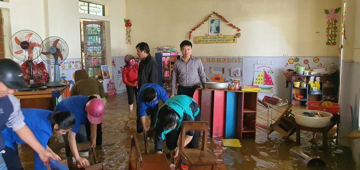 Ông Trần Xuân Hà (đứng bên phải) - Trưởng phòng GD&ĐT Thanh Chương, Nghệ An kiểm tra công tác dọn dẹp sau lũ tại các trường học trên địa bàn