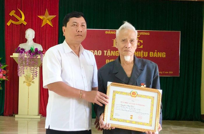 Đồng chí Trưởng Ban Nội chính Tỉnh ủy Phùng Tiến Quân trao Huy hiệu 60 năm tuổi Đảng cho đảng viên Nguyễn Hữu Đôn, chi bộ thôn Hưng Tiến, xã Phú Lương (Sơn Dương). Ảnh: Minh Thủy