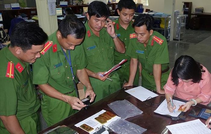  Cảnh sát giám định số vàng do các bị can vận chuyển trái phép. Ảnh: Công an cung cấp.