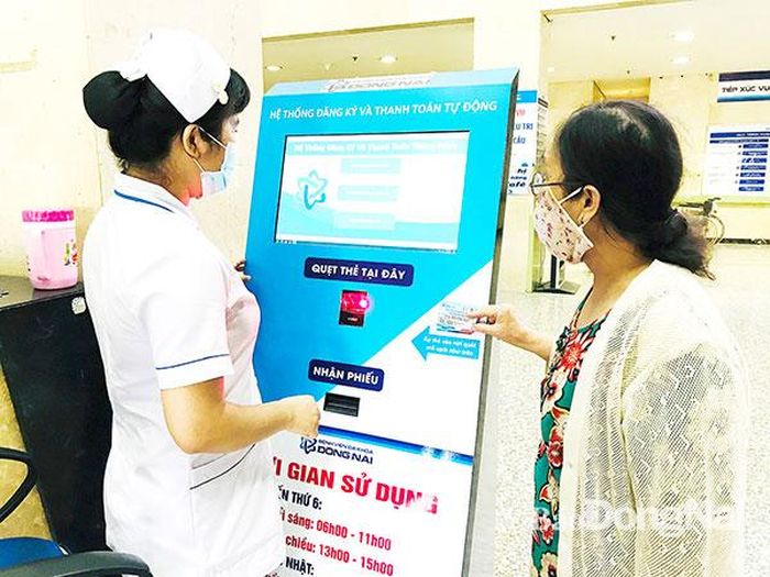 Nhân viên Bệnh viện Đa khoa Đồng Nai hướng dẫn bệnh nhân đăng ký khám bệnh bằng thẻ khám bệnh One Card. Ảnh: Phương Liễu