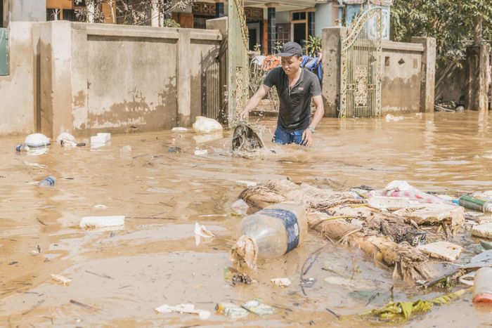 Gom rác và dọn vệ sinh trước cổng nhà