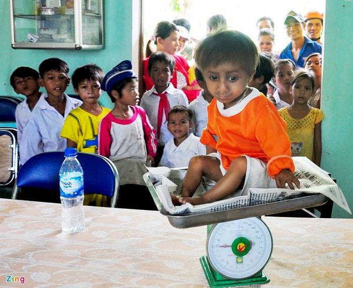  Trẻ em ở xã Sơn Ba tò mò khi các bác sĩ kiểm tra sức khỏe cho K'Rễ. Ảnh: Minh Hoàng. 