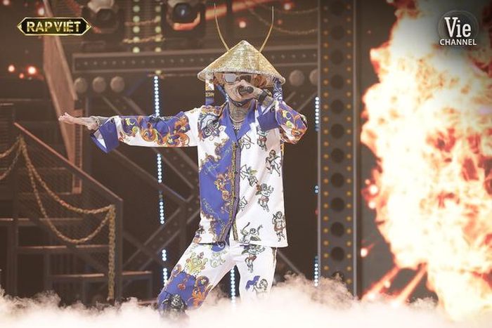  Bộ trang phục độc đáo nhất của Dế Choắt chính là set đồ họa tiết trong vòng Bứt phá. Phụ trách chuẩn bị quần áo và phụ kiện trình diễn cho Dế Choắt trong vòng thi này là Bo Bụi. Chia sẻ với Zing, Bo Bụi cho biết thời gian từ khi lên ý tưởng đến lúc hoàn thiện bộ đồ là một tháng. "Dế gần như hoàn toàn tin tưởng và thoải mái trong các quyết định của tôi. Hai anh em làm việc khá ăn ý nên có sự thống nhất tốt trong khoảng thời gian ngắn", anh nói. Ảnh: Rap Việt. 