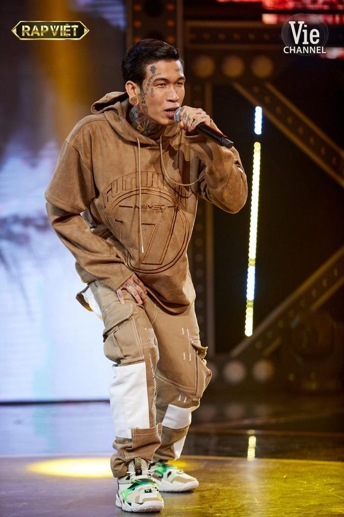  Đôi lúc, phong cách của Dế Choắt thiên hướng về gu ăn mặc kiểu streetwear. Tại vòng Đối đầu, nam rapper lựa chọn áo hoodie độc đáo với phần tay raglan ngắn và dài. Anh mặc đồ theo kiểu monochrome cùng quần túi hộp dạng đắp vải. Ảnh: Rap Việt. 
