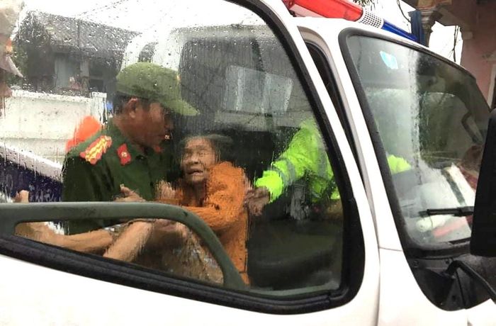 Công an hỗ trợ đưa người cao tuổi ở vùng thấp trũng TP Huế đến nơi an toàn, tránh bão số 13 vào trưa 14-11. Ảnh: TRẦN HỒNG