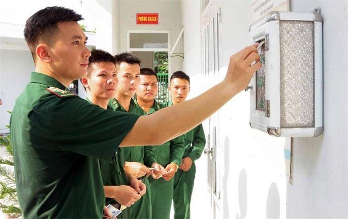 Cán bộ, chiến sĩ Đồn Biên phòng cửa khẩu cảng Bến Lức quyên góp tiền tại “Thùng nhân ái” để mua đồ dùng học tập cho các em học sinh. Ảnh: Hồ Phúc