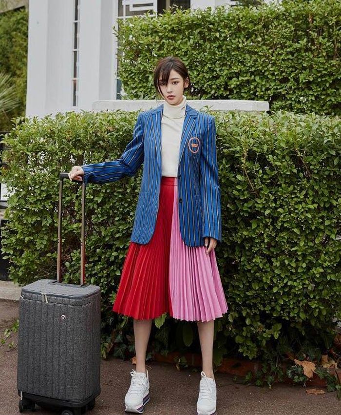 Trương Thiên Ái lại lựa chọn áo blazer kẻ để kết hợp cùng với chân váy xếp ly rất nữ tính và hút mắt.