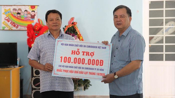 Ông Nguyễn Văn Khanh (phải) – Phó Chủ tịch Hội Nạn nhân chất độc da cam/dioxin Việt Nam trao bảng tượng trưng số tiền 100 triệu đồng cho đại diện Trung tâm Bảo trợ nạn nhân chất độc da cam và trẻ em bất hạnh TP Đà Nẵng.
