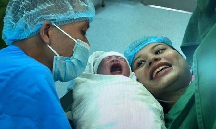 Nằm trên bàn đẻ, Lệ Thu vẫn luôn rạng rỡ nụ cười.