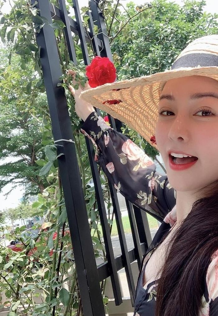 Nhật Kim Anh tự tay hái hoa hồng do mình trồng trước nhà đang nở rộ.