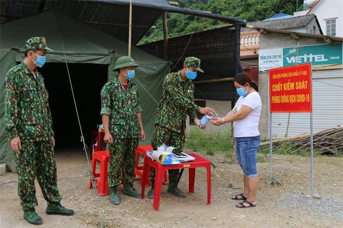 Cán bộ Đồn Biên phòng cửa khẩu Lý Vạn, BĐBP Cao Bằng thực hiện các biện pháp phòng chống dịch cho người dân qua lại điểm chốt Kéo Ái, xã Minh Long, huyện Hạ Lang, tỉnh Cao Bằng. Ảnh: Lê Đồng
