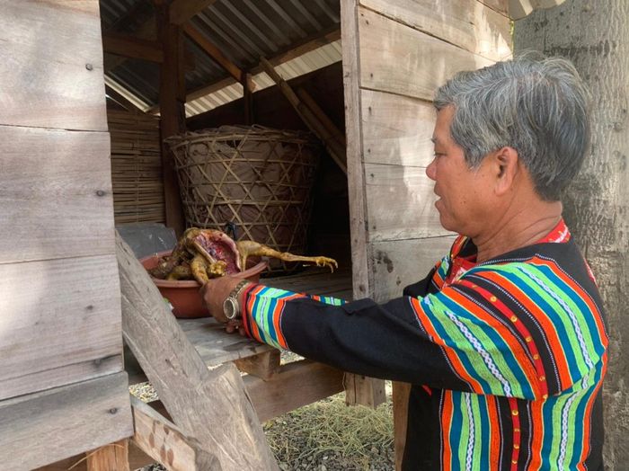 Già làng vừa khấn vừa mang lễ vật về kho để rước hồn lúa.