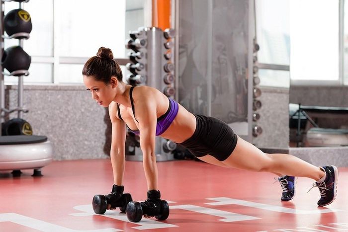  Chống đẩy với tạ: Bài tập này tác động lớn tới cơ lưng và làm săn chắc vùng cơ thể này. Cách thực hiện: Đặt hai quả tạ trên sàn và thực hiện tư thế chống đẩy, hai tay đặt tạ cách nhau rộng bằng vai. Lúc này, cơ thể phải cứng và phẳng như một tấm ván, tạo thành đường thẳng từ đầu đến chân. Giữ nguyên tư thế trong 30 giây. Sau khi tập bài này một thời gian, bạn nên tăng cường độ khó bằng cách chống đẩy với tạ thay vì chỉ giữ. Đồng thời, chúng ta có thể kết hợp giữ thăng bằng với một tay, tay còn lại nâng tạ lên sát ngực tương tự động tác ở trên. Ảnh: Eatthis.