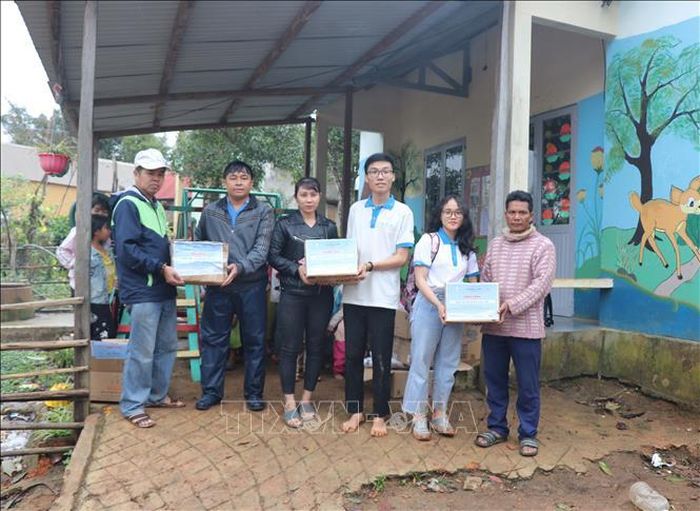 Các em học sinh nhóm thiện nguyện Fly to Sky mang áo ấm, sách truyện và bình lọc nước đến cho trẻ em làng Đê Kôn.