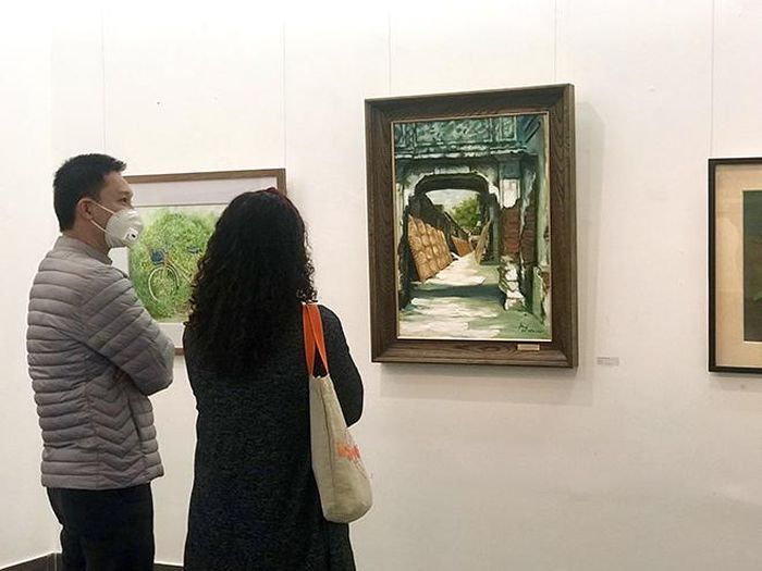 Khách tham quan triển lãm và tác phẩm của họa sĩ Nguyễn Bá Kiên
