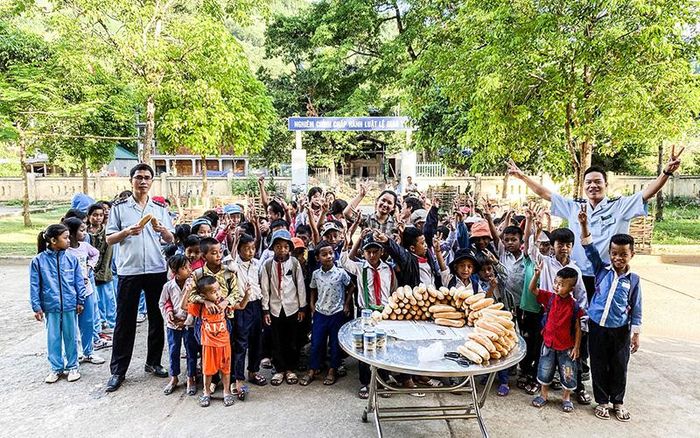 Đoàn viên Chi đoàn Hải quan Cửa khẩu quốc tế La Lay trao bánh mì cho học sinh vùng cao - Ảnh: T.P
