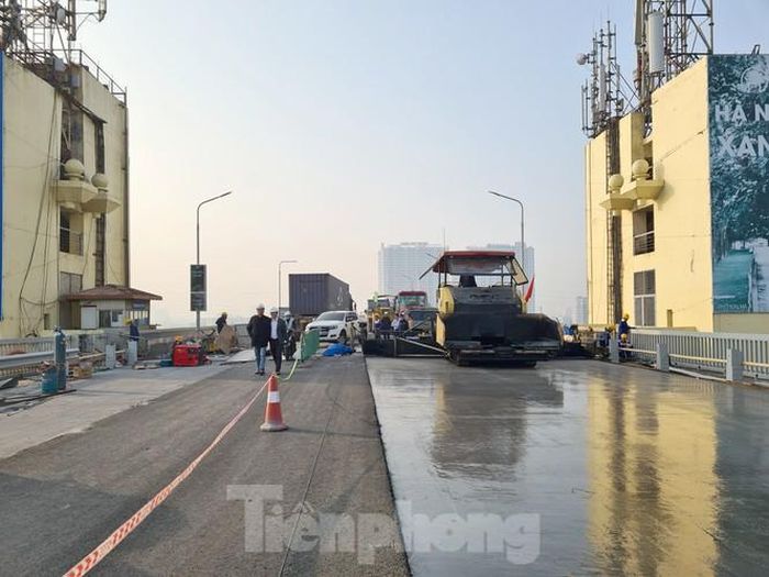 Một đoạn mặt cầu Thăng Long đã bắt đầu rải lớp bê tông nhựa tạm nhám (bên trái) lên trên phần bê tông UHPC đã đảm bảo độ cứng.