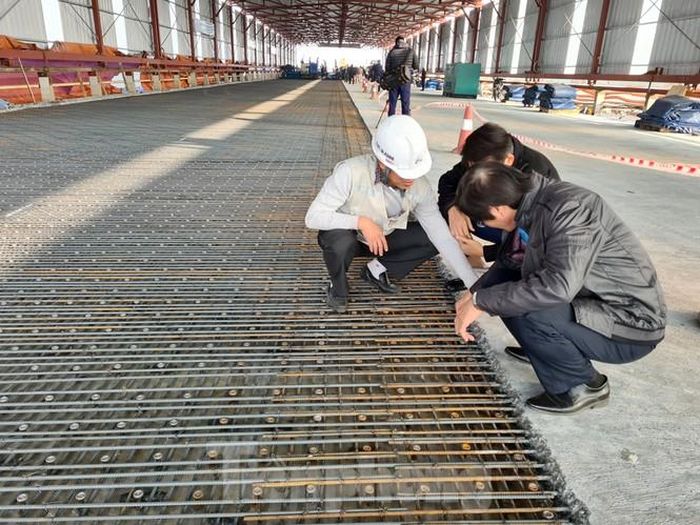 Kỹ sư của nhà thầu kiểm tra lại lớp bê tông UHPC đã đổ trướng đó và phần đinh neo, lưới thép cốt nền của mẻ bê tông cuối cùng chuẩn bị được đổ trên mặt cầu Thăng Long.
