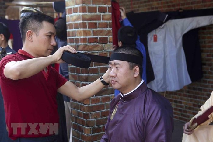 Khách mặc thử đồ truyền thống tại lễ hội. (Ảnh: Tuấn Đức/TTXVN)