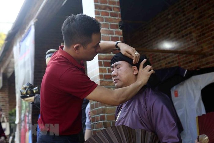 Khách mặc thử đồ truyền thống tại lễ hội. (Ảnh: Tuấn Đức/TTXVN)