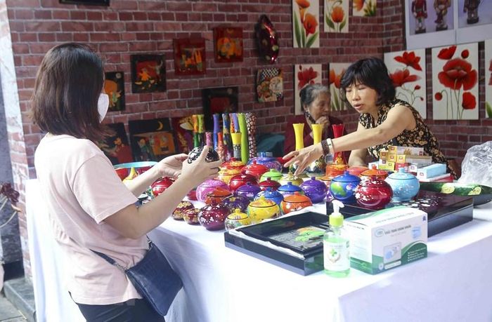 Khách xem các sản phẩm sơn mài của làng sơn mài Hạ Thái. (Ảnh: Tuấn Đức/TTXVN)