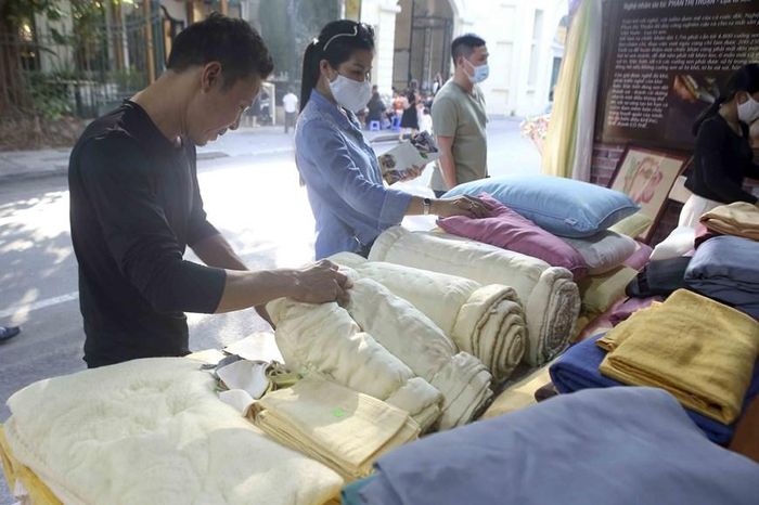 Khách tham quan gian hàng của làng dệt Phùng Xá. (Ảnh: Tuấn Đức/TTXVN)