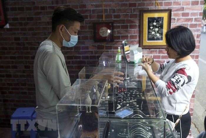 Khách mua hàng tại gian hàng của làng nghề đậu bạc Định Công. (Ảnh: Tuấn Đức/TTXVN)