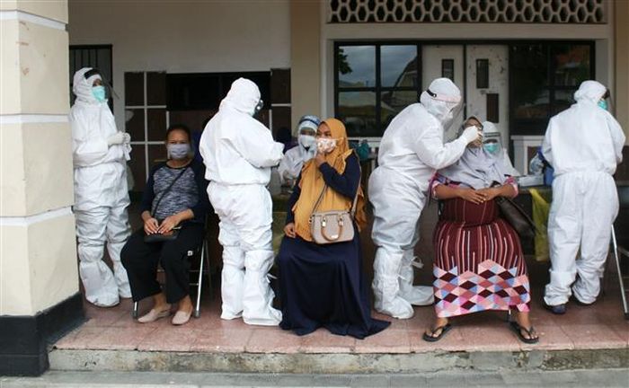 Nhân viên y tế lấy mẫu xét nghiệm COVID-19 cho người dân tại Surabaya, Indonesia ngày 8/12/2020. Ảnh: THX/TTXVN