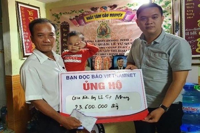 Đại diện báo VietNamNet (phải) trao số tiền bạn đọc ủng hộ đến gia đình