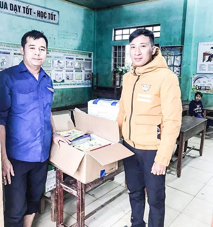  Anh Trần Hải Nam (trái) trao sách vở hỗ trợ các trường học vùng cao bị ảnh hưởng sau lũ - Ảnh: NVCC 
