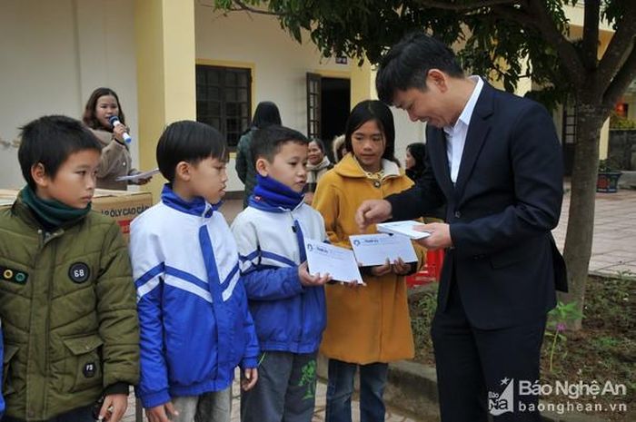 Ông Trần Văn Hiến - Phó Chủ tịch UBND huyện Đô Lương trao tặng quà cho học sinh. Ảnh: Xuân Thống