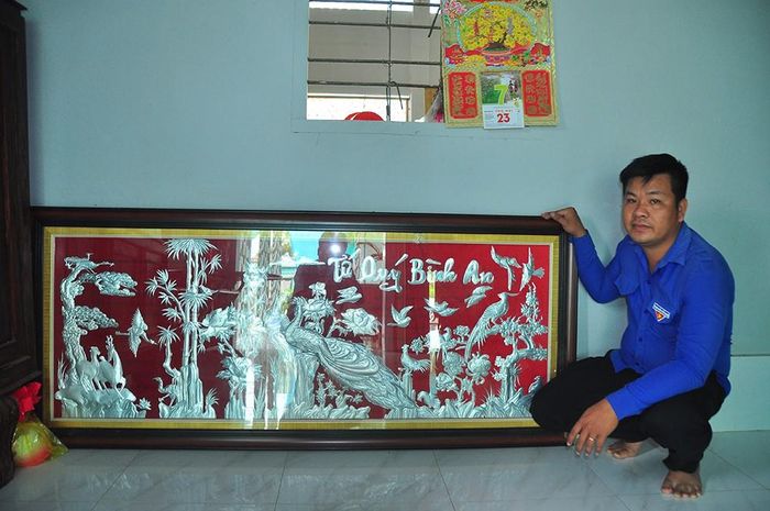 Nguyễn Khắc Vinh bên cạnh bức tranh nhôm Tứ quý Bình An của mình. - Ảnh: Hòa Hội