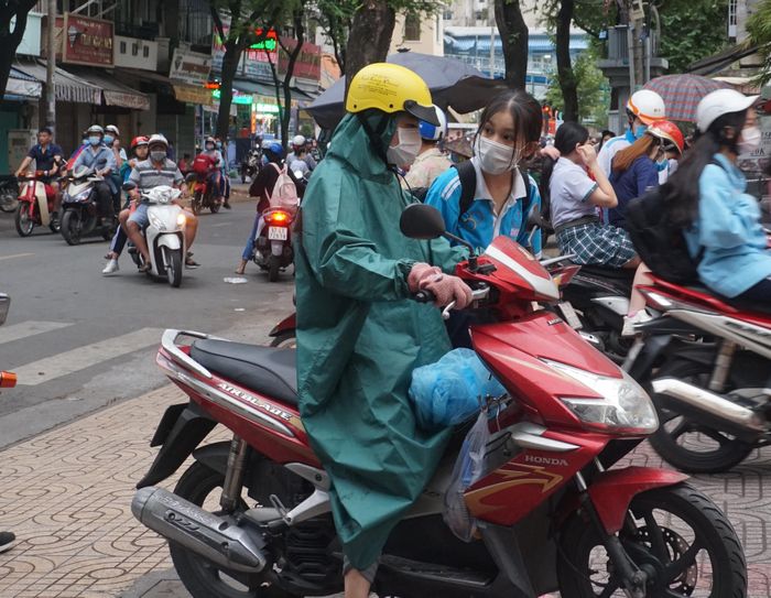 Phụ huynh đội mưa chở con đến trường sáng 22/12.