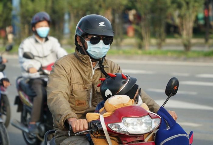 Người dân đi làm trong trang phục "mùa đông" tại TPHCM. 