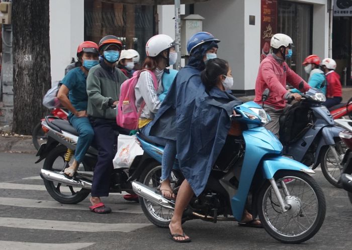 Người dân đi làm, đưa con cái đi học trong cơn mưa, kèm cái lạnh cuối năm.