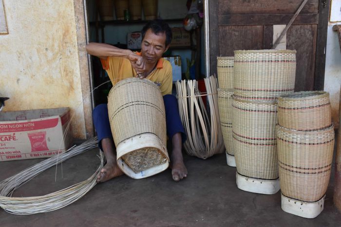 Ông Rơ Châm Kơmlo cặm cụi đan gùi. Ảnh: Hà Phương