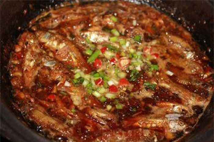 Cho nồi cá lên bếp, kho cá lửa nhỏ, hớt bọt, thỉnh thoảng múc ít nước cá tưới lên trên mặt cá cho cá thấm đều gia vị.