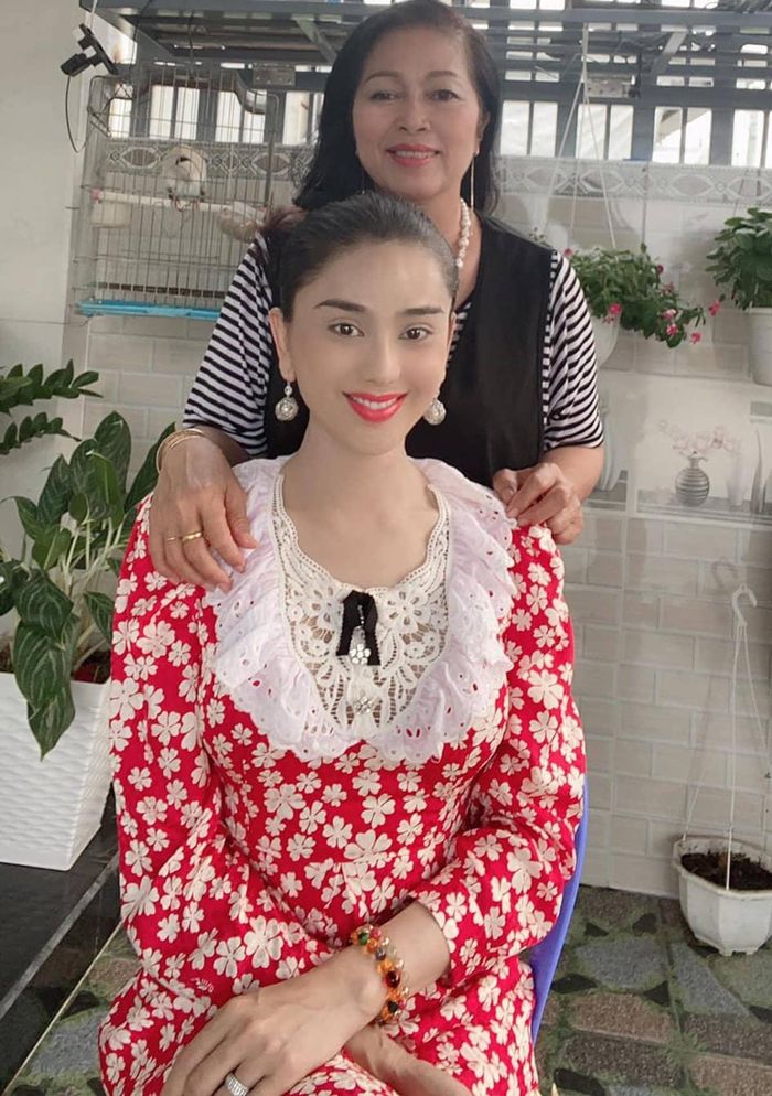 Khoe ảnh chụp bên mẹ chồng, nhan sắc của cả hai người đẹp đều được cho là trẻ trung và rạng rỡ. Dù vậy, điều khiến mọi ánh nhìn "dán chặt" mắt vào chính là bộ trang phục kín đáo và nền nã của Lâm Khánh Chi. Thiết kế váy hoa đỏ, phối ren ngay thềm ngực giúp cô theo đuổi thành công style "bánh bèo". Để tăng thêm độ sang chảnh cho bộ cánh, Lâm Khánh Chi chốt hạ tổng thể bằng đôi hoa tai to sụ. 