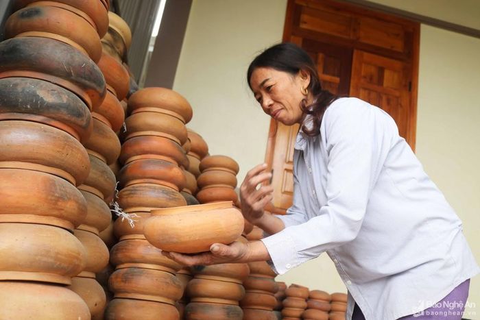 Cứ ngỡ nghề buôn nồi đất phải đi xa, vận chuyển khó khăn… chỉ có đàn ông mới làm được, nhưng một số phụ nữ ở Viên Sơn lại đảm đang khá tốt. Bà Bùi Thị Nhường (45 tuổi) đã có 10 năm chuyên đi mua nồi, vận chuyển nồi ở Trù Sơn về cho chồng bán. Bà Nhường không chỉ sành sỏi việc lựa chọn nồi, mà còn sắp xếp, chuyên chở nồi bằng xe máy không thua cánh đàn ông. Theo bà Nhường, chọn nồi đất là phải gõ để nghe tiếng kêu, nếu âm thanh trong, vang thì nồi “chuẩn”, còn tiếng rè rè là nồi đã rạn vỡ. Ảnh: Huy Thư