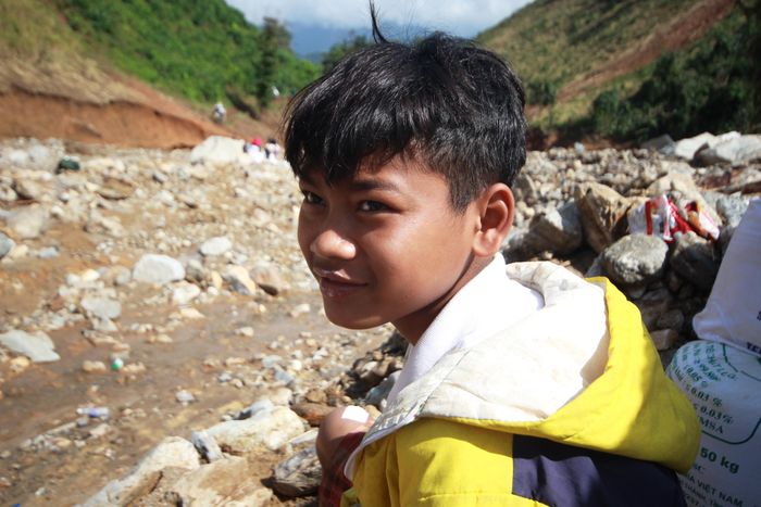 “Shiper nhí” Hồ Ðình Nghĩa hăng hái cùng dân làng cõng hàng cứu trợ