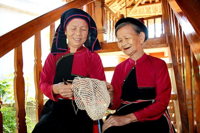Bà Trần Thị Kỳ (bên phải) giới thiệu về chiếc xung - đồ dùng không thể thiếu của đồng bào dân tộc Cao Lan, huyện Đoan Hùng.