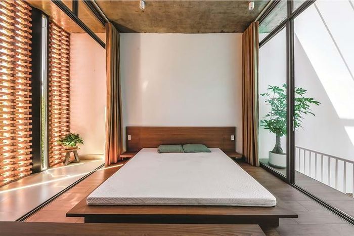 Giữa hai phòng ngủ là một hành lang kết nối - nơi mà hiệu ứng bóng đổ diễn ra tạo nên nhiều cảm xúc trong ngày. Việc nâng cốt cao độ của phòng ngủ chính giúp tầng trệt có một cao độ thoáng hơn, ngoài ra còn đem lại cảm giác tiếp cận không gian mới lạ hơn. Hai bên phòng ngủ chính là các cửa lùa giúp gia chủ linh hoạt trong việc thông thoáng các phòng một cách tự nhiên.