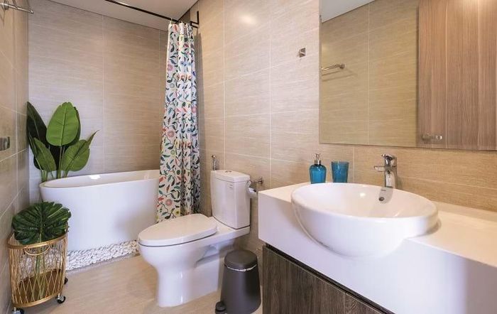 Phòng tắm với rèm họa tiết và cây xanh mang lại sự dễ chịu vào cuối ngày làm việc.